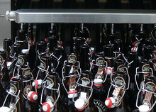 Pre-Sprinkling of the bottles for pre-heating with used process water on the feed board